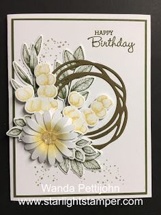 a birthday card with white flowers and green leaves on the bottom, in front of a black background