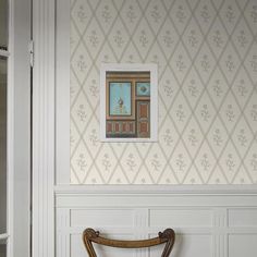 a wooden chair sitting in front of a white wall