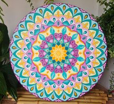 a colorful plate sitting on top of a bamboo mat next to some potted plants