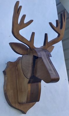 a wooden deer head mounted to the side of a building