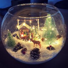 a glass bowl filled with snow and christmas decorations