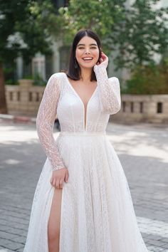 a woman in a white dress posing for the camera