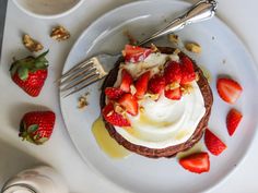 a plate topped with a desert covered in whipped cream and strawberries