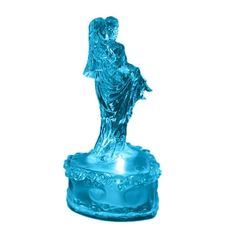 a blue glass figurine sitting on top of a table next to a white wall