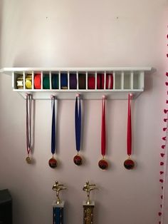 several medals are hanging on the wall next to two faucets and a speaker