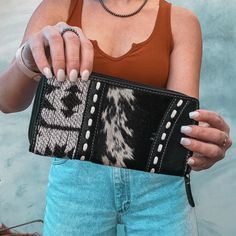 "Materials RUG, LEATHER AND HAIRON Item Width 7.5\" Item Height 4\" We are never going to be over black and monochrome and that is a fact because this wallet is giving all the trendy vibes we need. Cowhide on both sides!  *please note that cowhide may differ*" Trendy Black Leather Wallet, Trendy Leather Clutch Wallet, Black Leather Clutch With Snap Closure, Western Wallets, Cowhide Wallet, Myra Bags Cowhide, Cowhide Phone Case, Western Leather Wallets With Card Slots, Western Leather