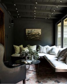 a living room filled with lots of furniture and decor on top of a brick floor