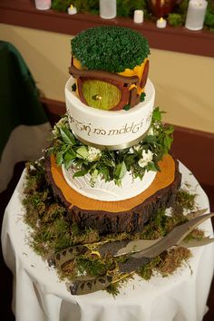 a three tiered cake decorated with broccoli and other plants on top of a table