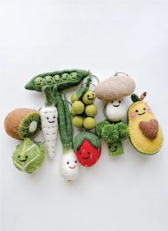 a group of stuffed fruits and vegetables hanging from strings