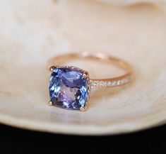 a tan and purple ring sitting on top of a white plate