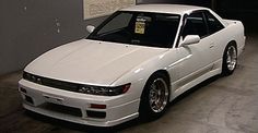 a white sports car parked in a garage