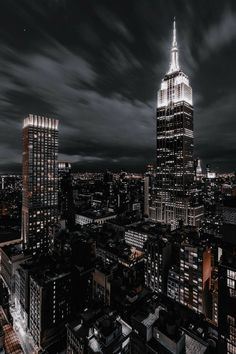 an aerial view of the empire building in new york city at night with dark clouds