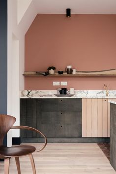 a kitchen with pink walls and wooden floors