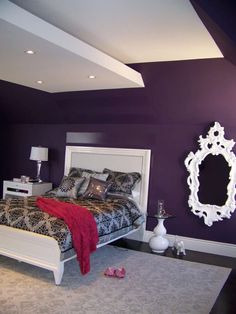 a bed room with a neatly made bed and purple walls