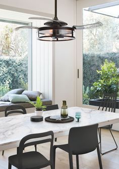 a dining room table with chairs and a light fixture hanging from it's ceiling