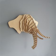 an elephant made out of cardboard hanging on the wall