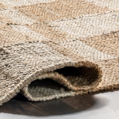 a close up of a rug on the floor with a white and brown color scheme