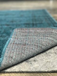 a close up view of a rug on the floor with blue and grey colors in it