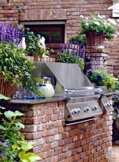 an outdoor bbq with lots of plants and flowers growing on the side of it