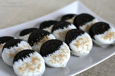 oreo cookies with white frosting and gold sprinkles on a plate