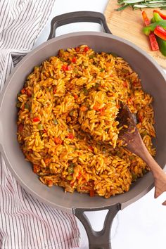 a pan filled with rice and vegetables on top of a table