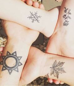 three people with tattoos on their feet are holding hands in the shape of a sun and snowflake