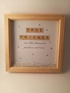 a scrabble frame with the words true friends on it and some tiny beads