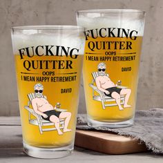 two glasses with funny sayings on them sitting next to a cutting board and towel