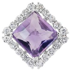 This captivating ring features a magnificent square cushion mixed-cut amethyst as its centerpiece, boasting an impressive weight of 10.56 carats. The rich purple hue of the amethyst exudes elegance and allure, capturing the eye with its vibrant coloration. With its transparent clarity, the amethyst showcases its natural beauty, allowing light to pass through and illuminate its facets. Surrounding the captivating amethyst are twenty round brilliant-cut diamond side stones, totaling 1.60 carats. G Amethyst And Diamond Ring, Cushion Ring, Jewelry Auction, Diamonds Ring, Exclusive Jewelry, Purple Hues, Belleza Natural, Selling Jewelry, Amethyst Ring