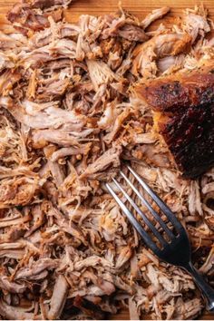 a pile of shredded meat next to a fork