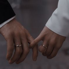 two hands holding each other with wedding rings on their fingers