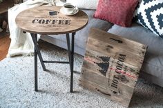 a coffee table sitting on top of a wooden crate next to a couch with pillows