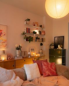 a living room filled with lots of furniture next to a wall mounted shelf full of candles