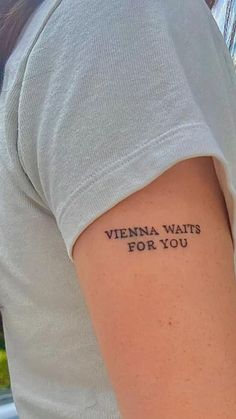 a woman with a tattoo on her arm that says, vienna waits for you in black ink