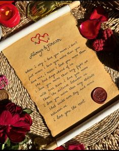 a piece of paper with writing on it next to some flowers and other items in the background