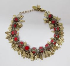 Created by Stefanie Wolf, a Martha's Vineyard jewelry designer who lives year-round in Oak Bluffs, this bracelet features a fringe of 14-karat gold-plated leaves paired with antique-style Czech red glass beads. Bracelet with lobster clasp is adjustable from approx. 7" to 8" (17.8cm - 20.3cm). Metal tag on clasp reads "Stefanie Wolf." An eye-catching piece in excellent vintage condition. Red Bohemian Bracelets For Celebration, Bohemian Red Bracelets For Celebrations, Red Czech Glass Bracelet, Gold Czech Glass Hand-strung Bracelet, Silver Bracelets With Lobster Clasp And Czech Glass, Bohemian Red Czech Glass Beads, Fringe Bracelet, Glass Beads Bracelet, Czech Glass Bracelet With Lobster Clasp