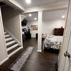 a bedroom with a bed and stairs leading to another room