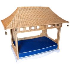 a wicker gazebo with blue cushion under it on a white background for display