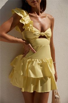 Immerse yourself in the enchanted wonders of world in the Ruffled Out Dress in Yellow, the perfect dress to wear for a romantic getaway. Pair with white strappy heels and sparkling jewellery to adorn.  Mini dress, true to size Knot front One shoulder strap with ruffle  Interior grip lining Tiered ruffle skirt Invisible back zipper with hook and eye  Lined  100% Cotton. Lining: 100% Polyester  Non-stretch material Please refer to the care label on garment for specific instructions on how to care for it Model wears XS Length from bust to hem: 63cm on an S Chest 37cm, Waist 32cm, size S White Strappy Heels, Yellow Mini Dress, Tiered Ruffle Skirt, Romantic Getaway, Sparkle Jewelry, Runway Trends, Dress Yellow, Out Dress, Care Label