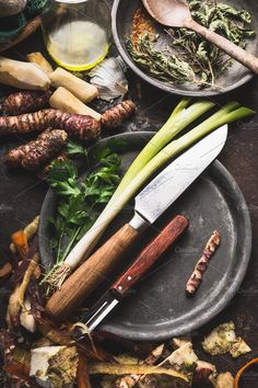 several different types of vegetables on plates with knives and spoons next to each other