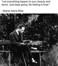 a black and white photo of a man sitting on a park bench reading a book