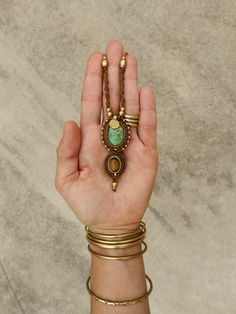 a woman's hand holding several different bracelets