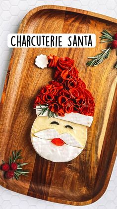 a wooden platter with a santa face on it and red roses in the center