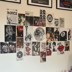 a wall covered in posters and pictures next to a table