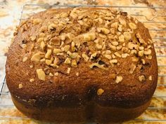 a close up of a cake on a cooling rack with nuts in the top half