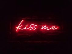 a red neon sign that says kiss me