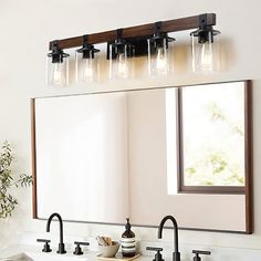 a bathroom vanity with three lights and a mirror