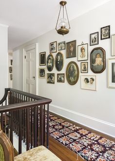 a hallway with pictures on the wall and rug