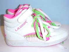 a pair of white shoes with pink, green and yellow laces on the side