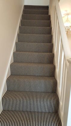 the stairs are lined with black and white striped carpet